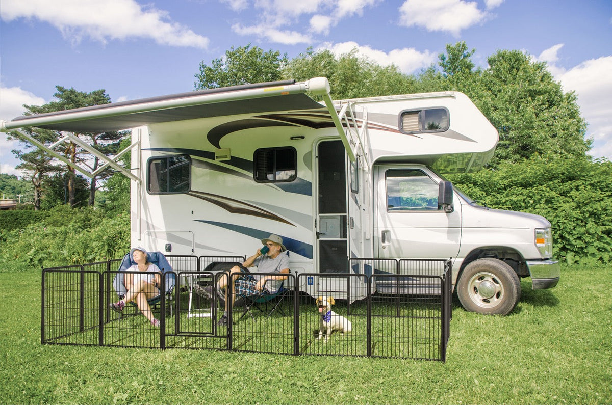 Two people rving with dog in a playpen