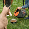 A man is feeding the dog with dog food travel bag